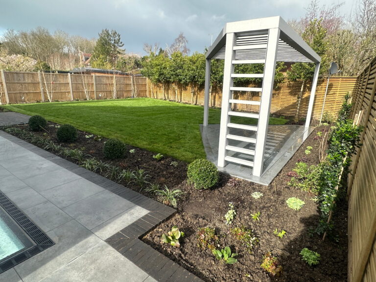 A modern garden featuring a manicured lawn, sleek pergola, and neatly arranged flower beds along a stone path